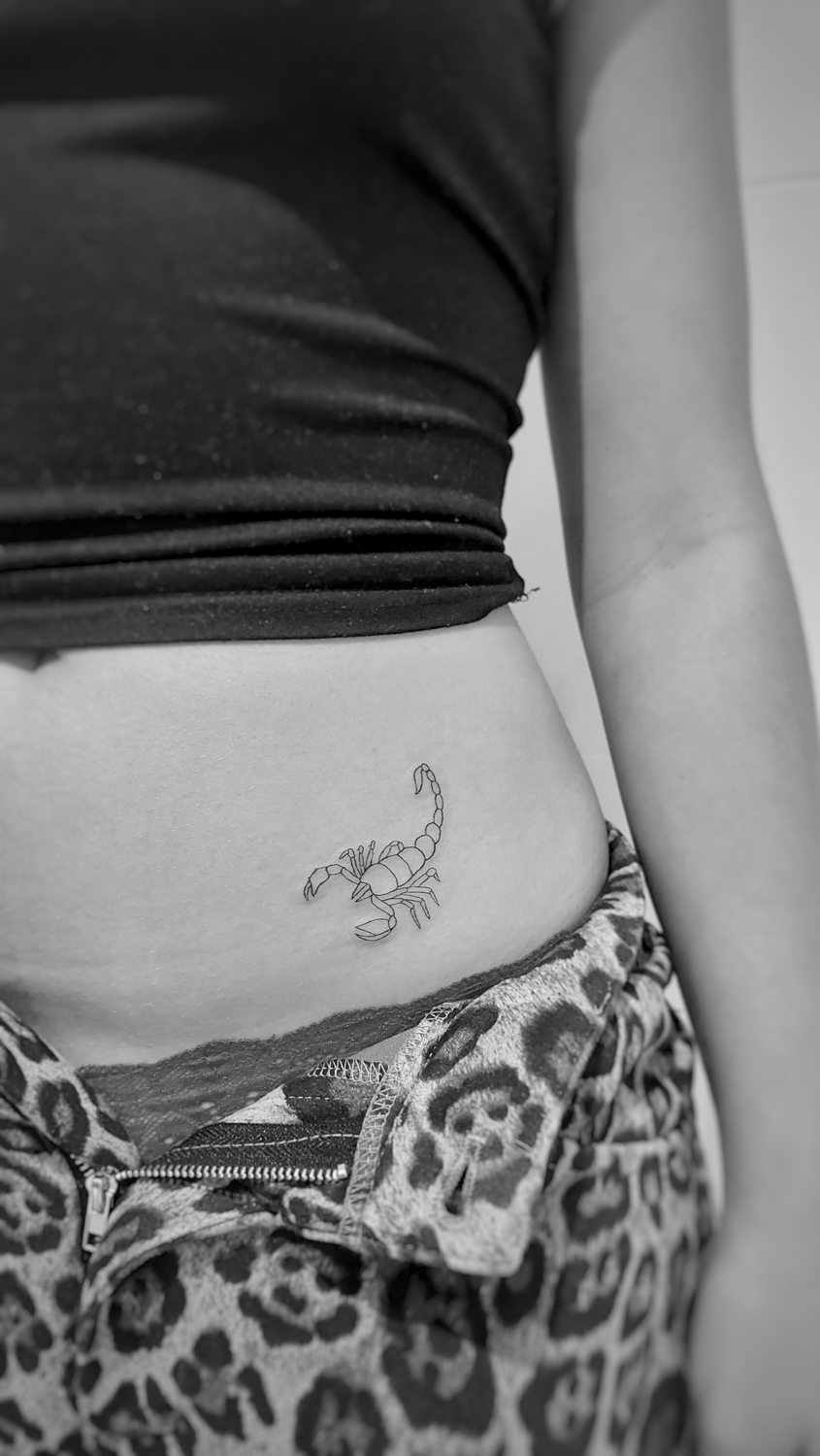 Tatuaje escorpión en abdomen de mujer