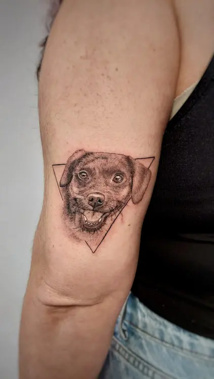 Tatuaje de perro sonriente en el brazo.