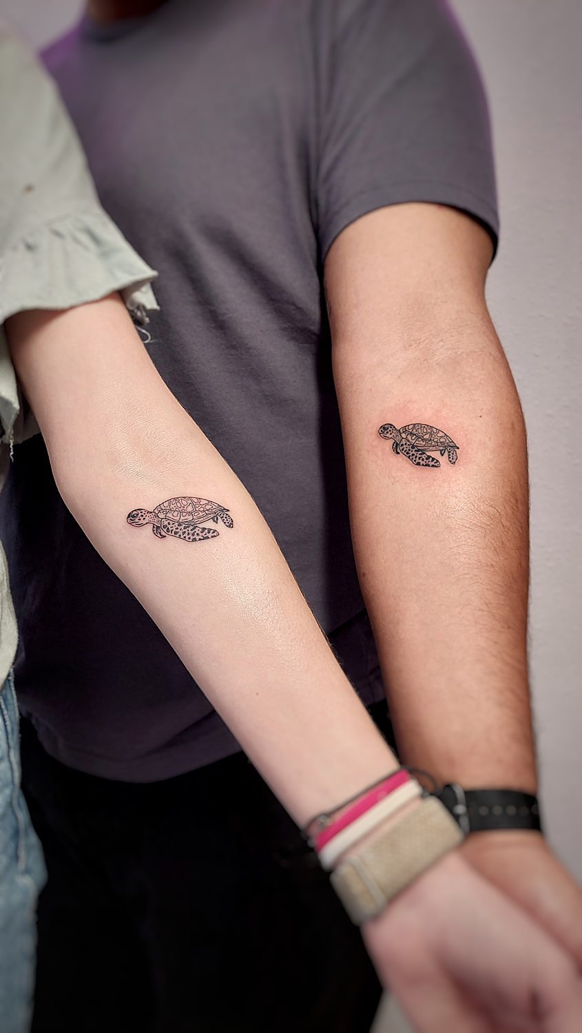 Tatuajes de tortugas en antebrazos de dos personas.