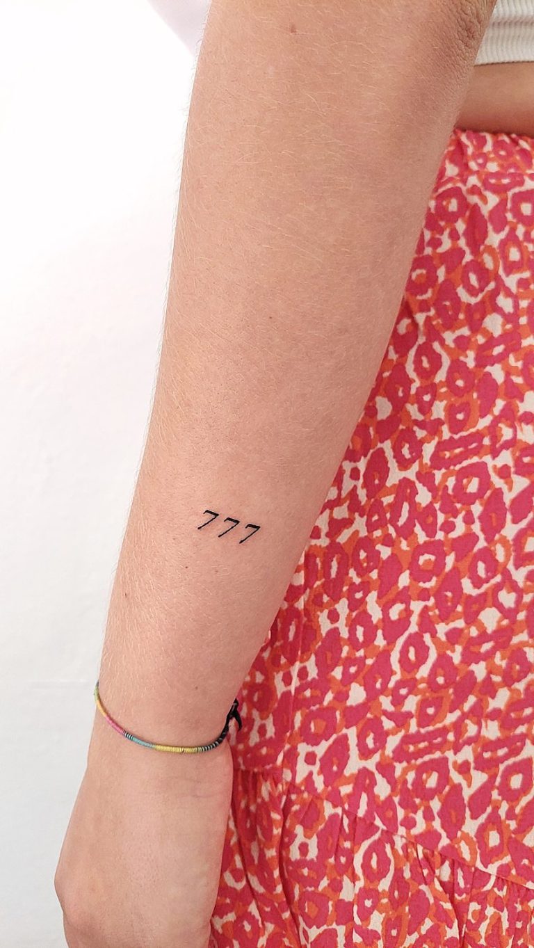 Tatuaje de número 777 en el antebrazo