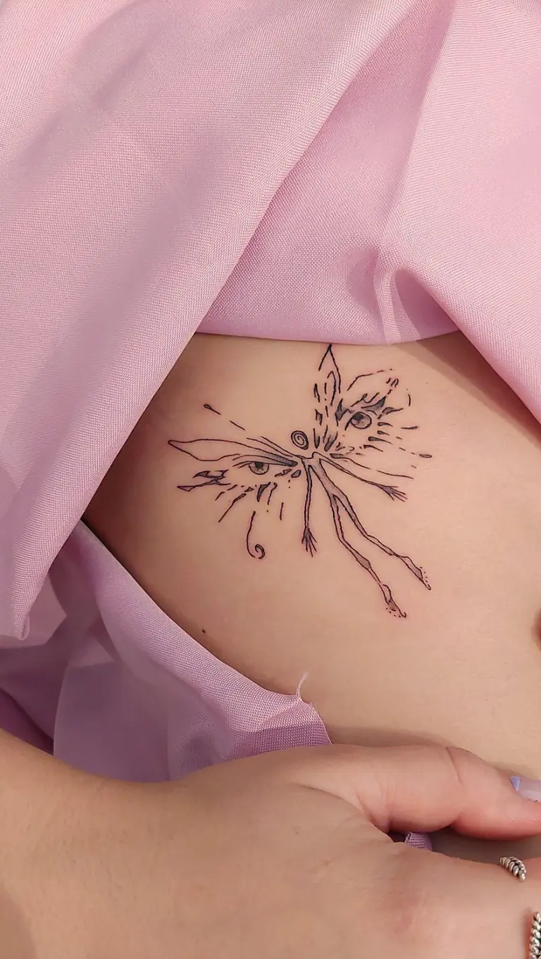 Tatuaje de mariposa con ojos en la barriga con estilo fine line