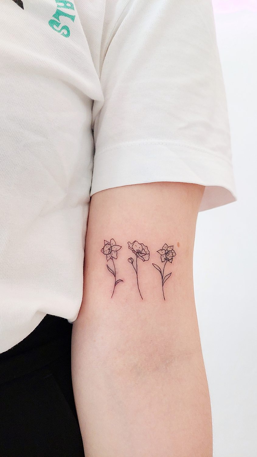 Tatuaje de tres flores en el brazo