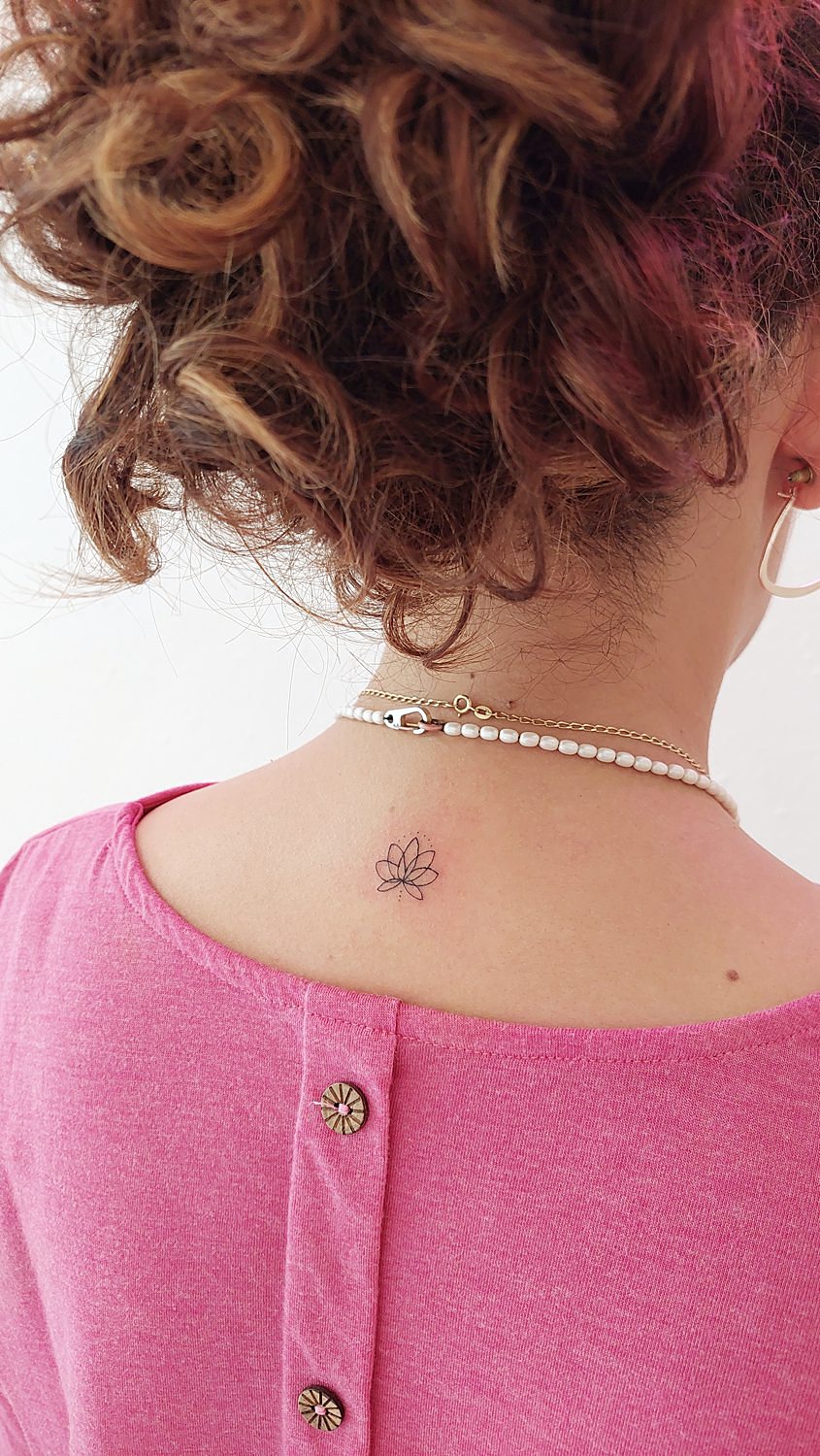 Tatuaje de flor de loto en la nuca