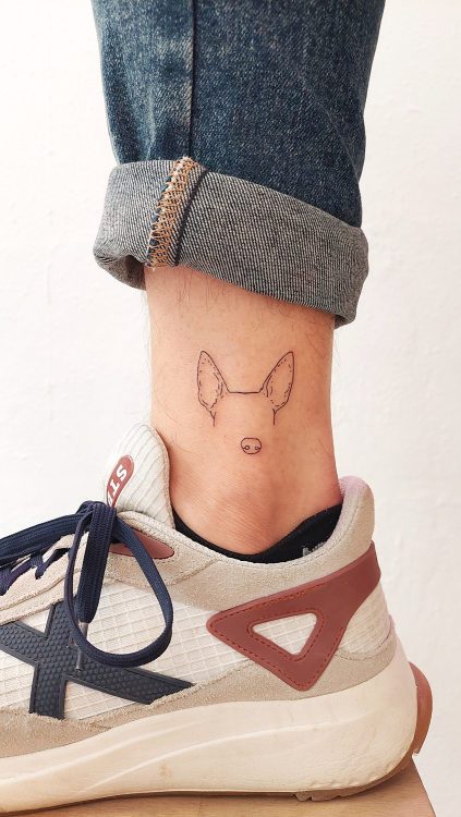 Tatuaje de perro minimalista en tobillo