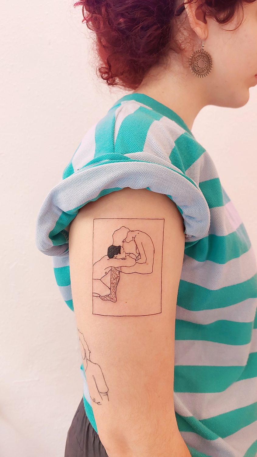 Tatuaje de un cuadro con figuras humanas abrazándose en el brazo.