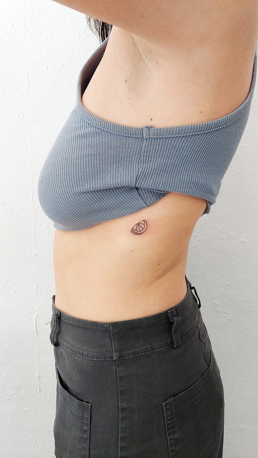 Tatuaje pequeño de cítrico en el costado