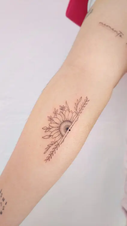Tatuaje de girasol en el brazo hecho con técnica de línea fina en un estudio de Valencia