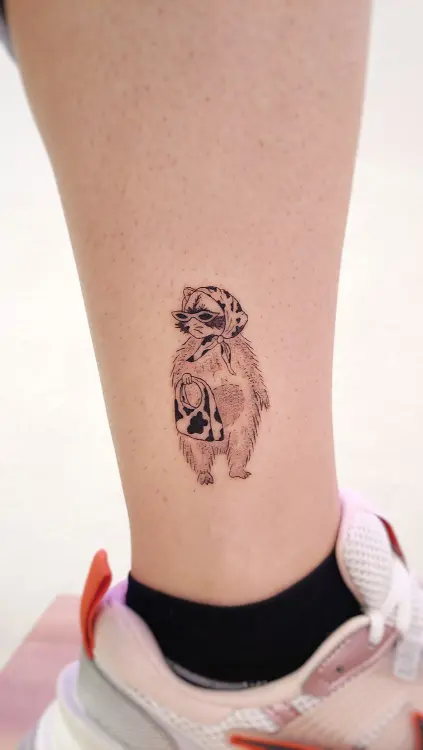 Tatuaje de mapache elegante en la pierna