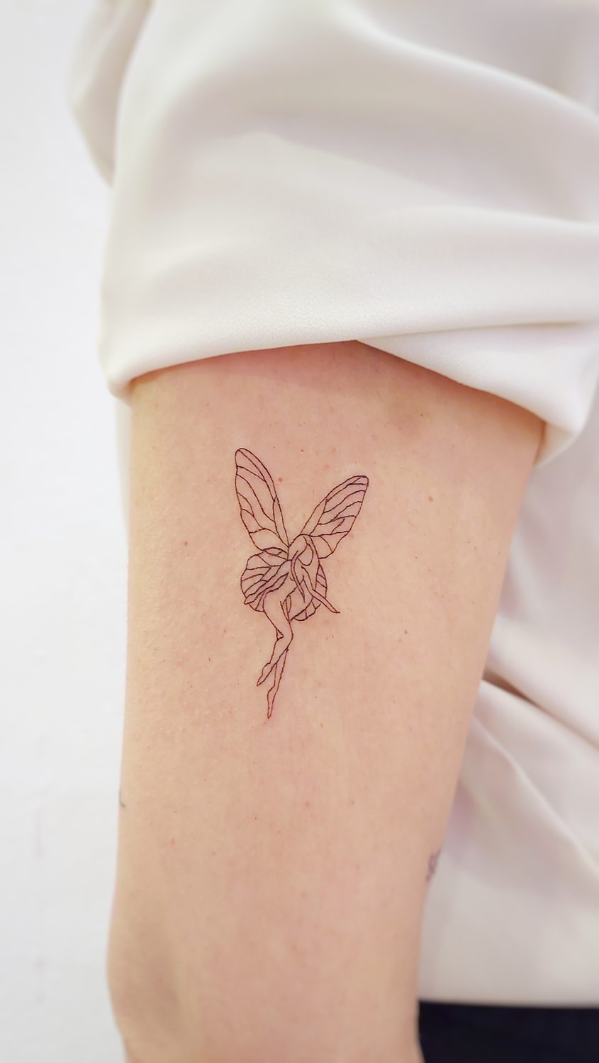 Tatuaje minimalista de hada en el brazo