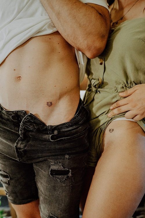 Pareja con tatuajes pequeños de vaca mini en la cadera