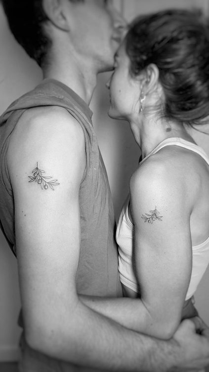 Pareja con tatuajes de ramas de olivo.