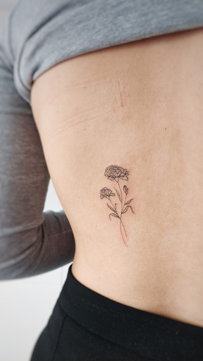 Floral rib tattoo on person's side made using fine line technique in a tattoo studio in Valencia, Spain