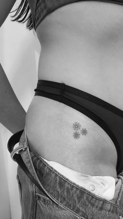 Tatuaje de flores en la cadera.