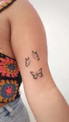 Tatuaje de mariposas en brazo de chica
