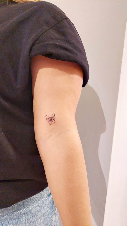 Tatuaje de mariposa en brazo interior de mujer.