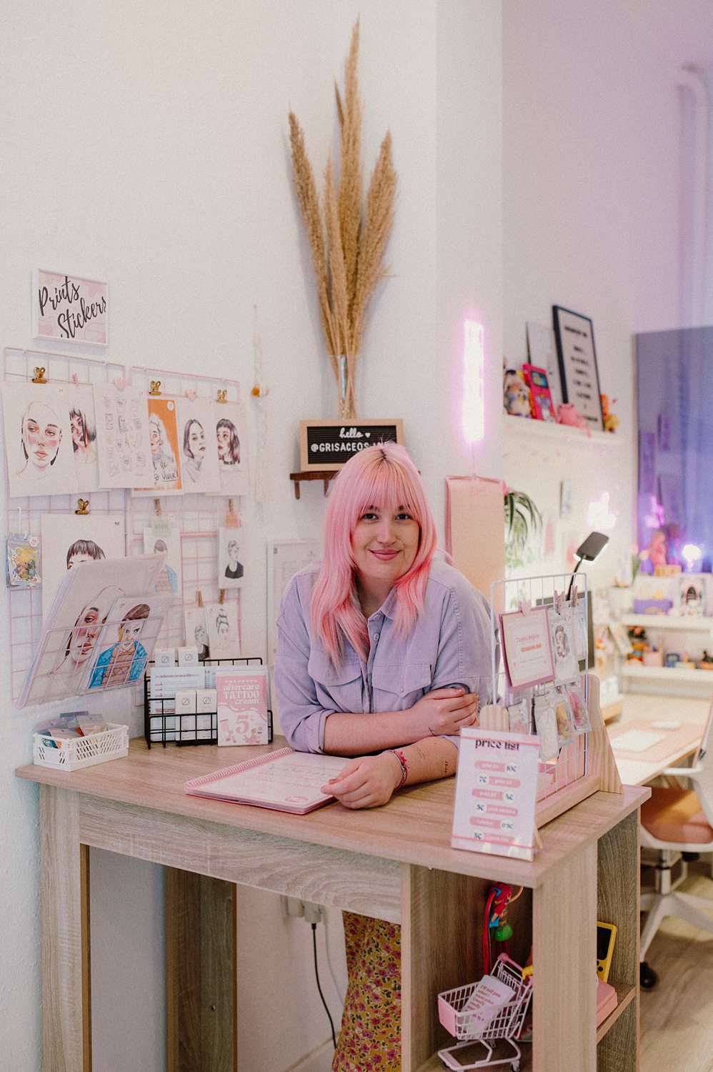 Mujer con cabello rosa en estudio artístico.