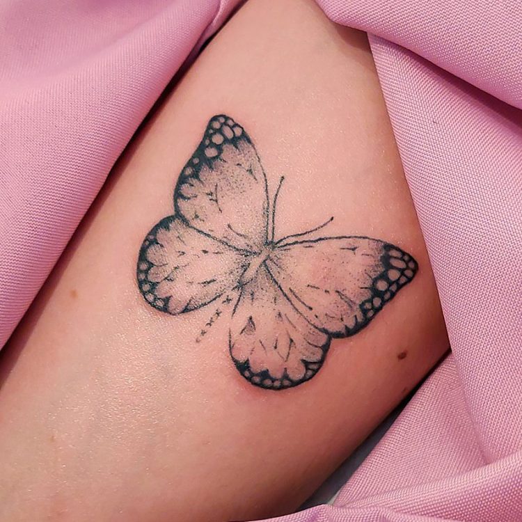 Tatuaje de mariposa negra en piel clara.