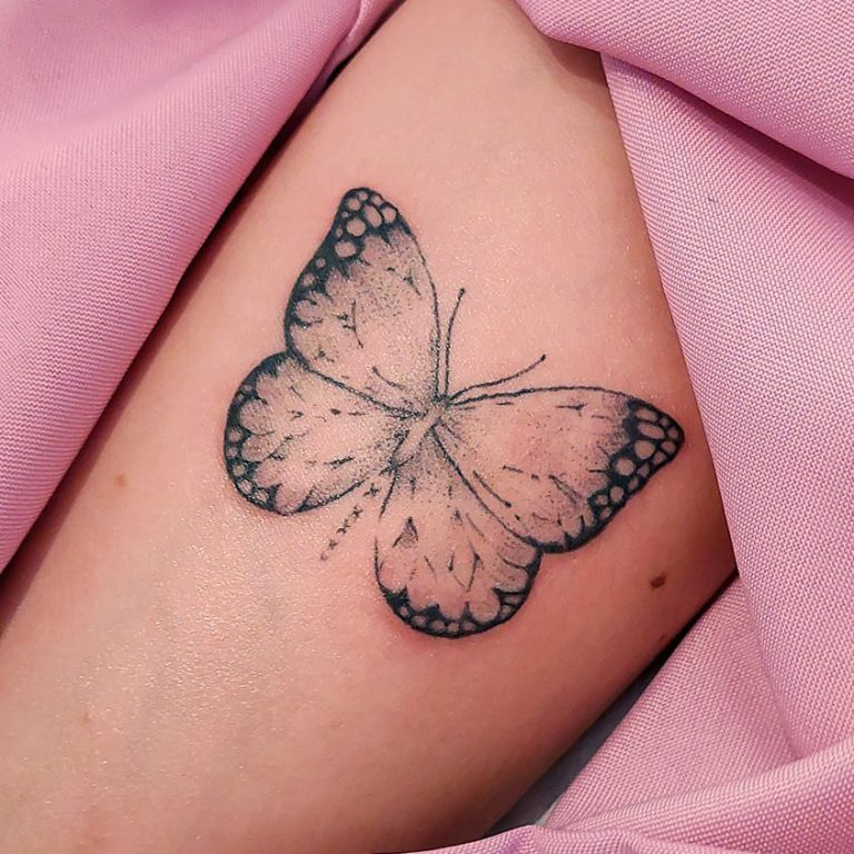 Butterfly tattoo on skin with pink fabric
