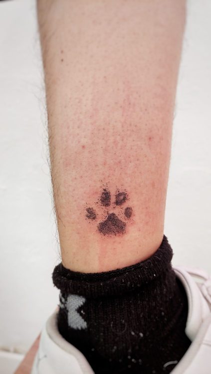 Tatuaje de huella en la pierna de persona.