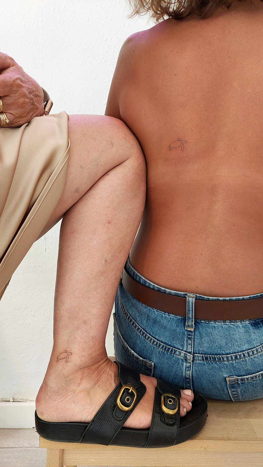 Tatuajes de tortugas en pie y espalda descubiertos.