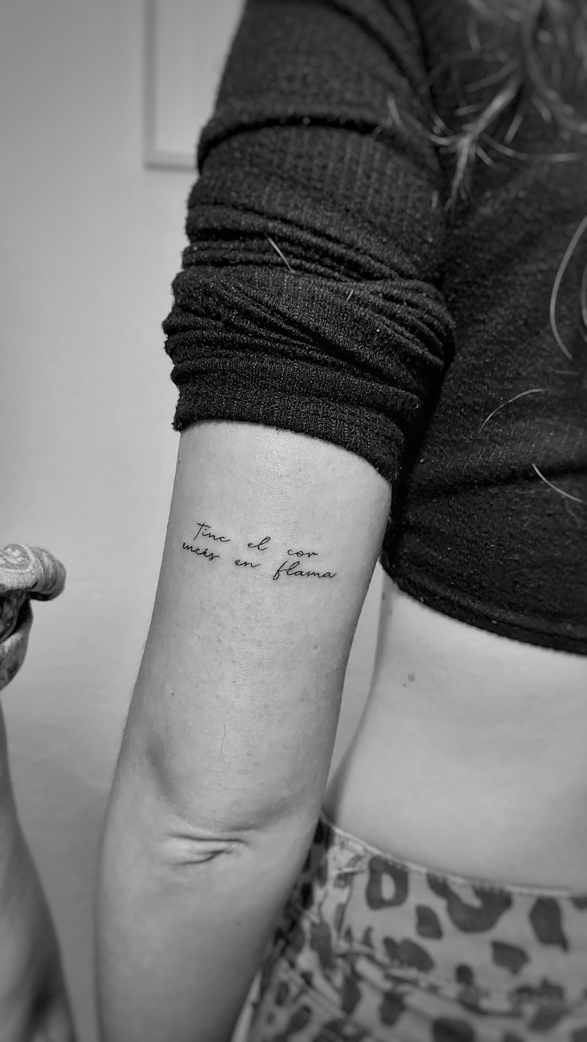 Tatuaje en el brazo con texto en cursiva.