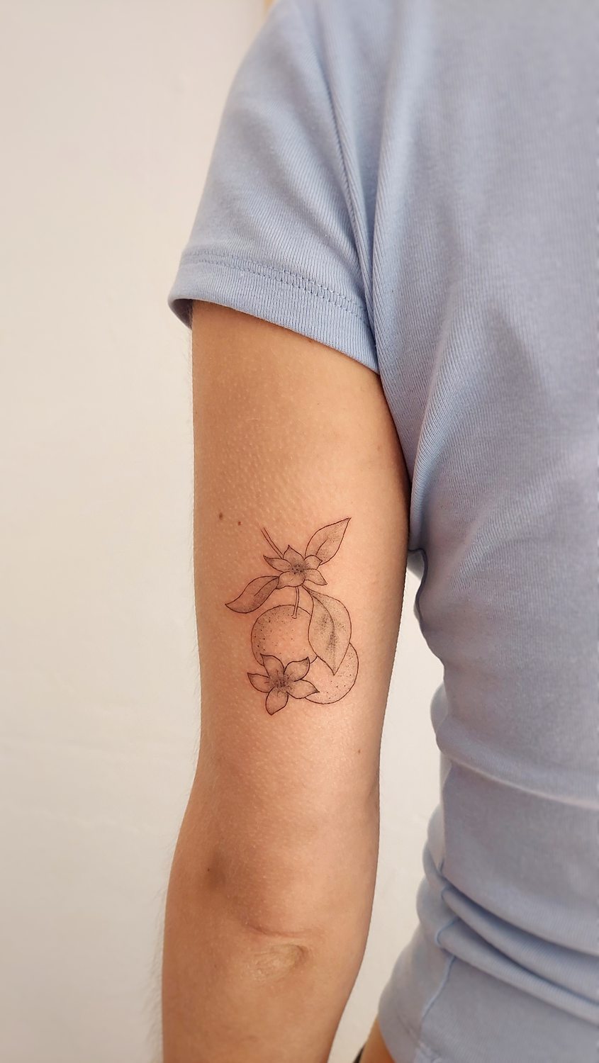 Tatuaje minimalista de naranja en el brazo