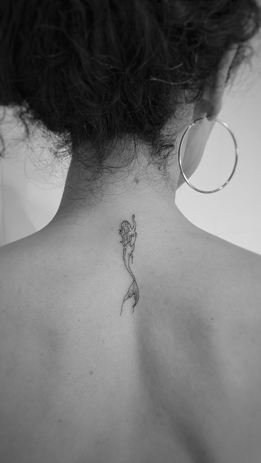 Tatuaje sirena pequeña en la nuca mujer.